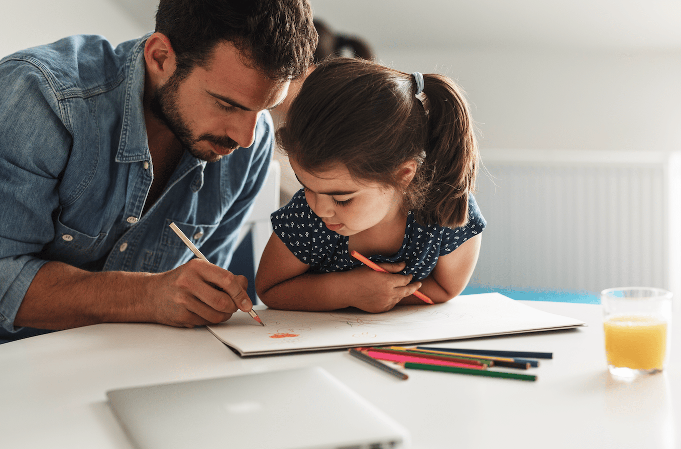 A child colouring with her father