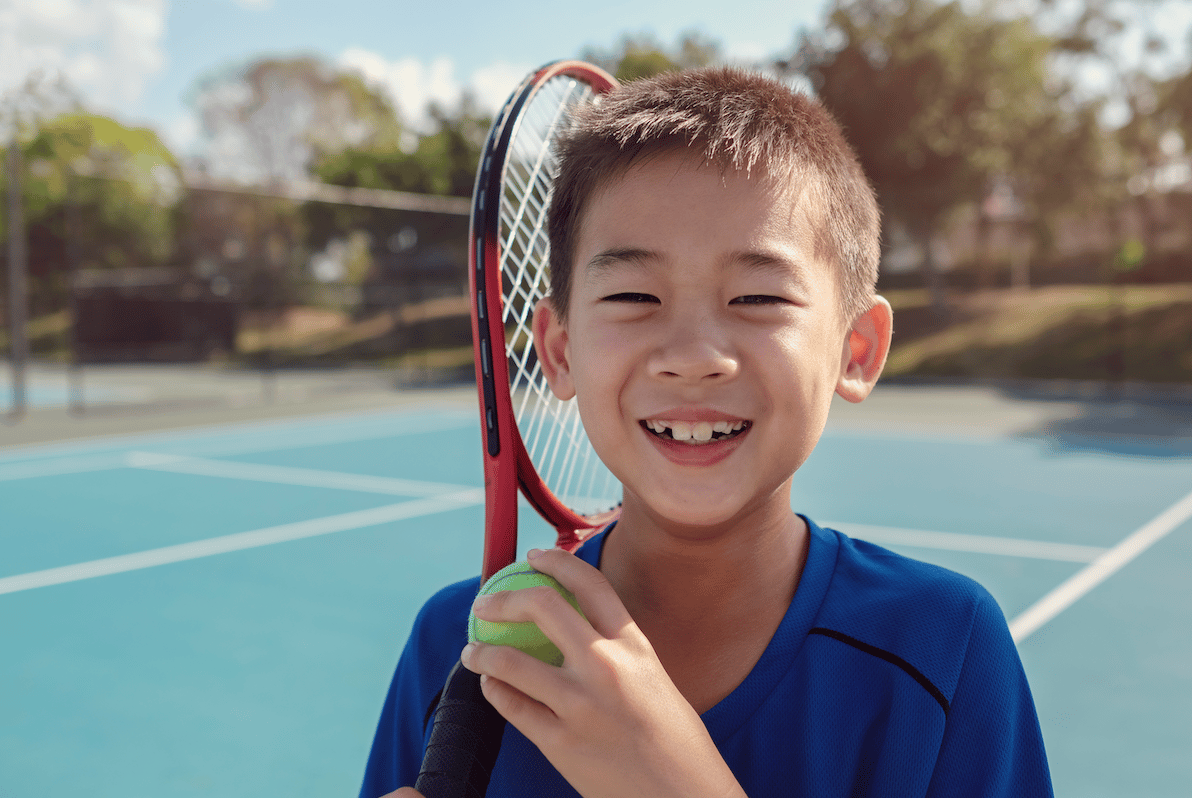 Boy playing tennis in PE