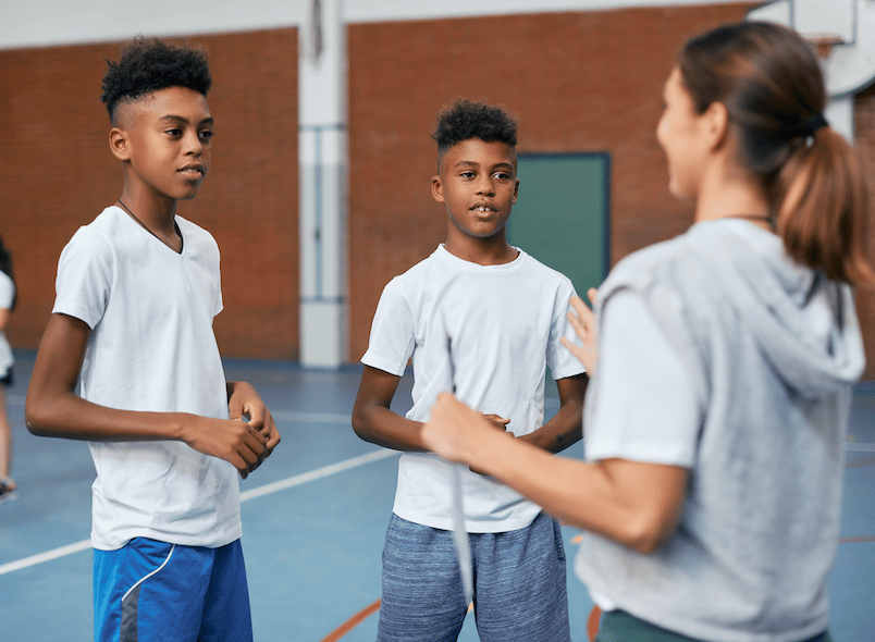 Children and teachers talking in PE 