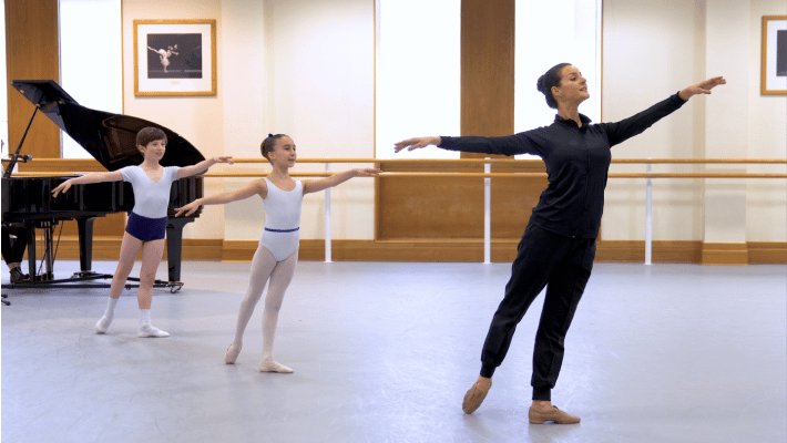 A group of dancers, including a primary school age child practising ballet
