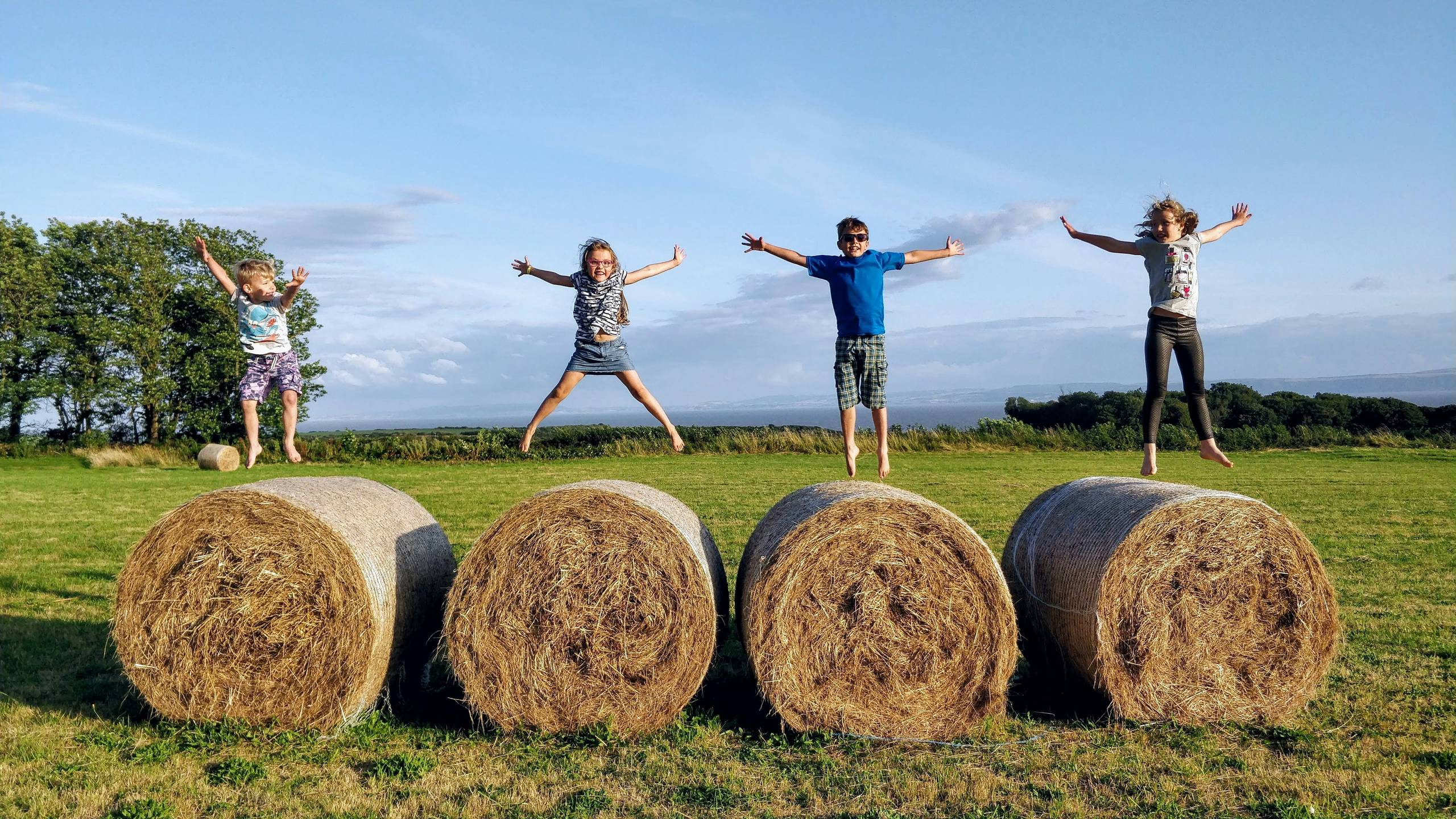 A group of children jumping on some hay